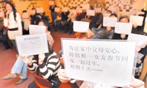 A man holds a piece of paper that says renting a girlfriend to visit parents with during the Spring Festival. 