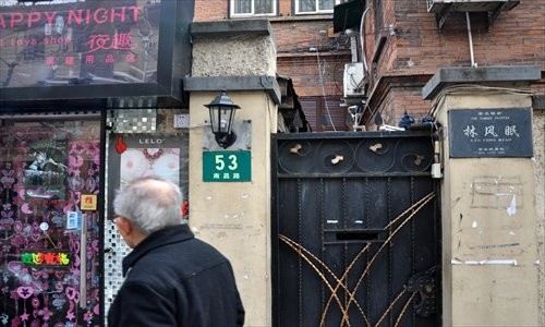 A passersby pauses Thursday, after passing the former residence of Lin Fengmian on Nanchang Road as adult products inside a sex shop catch his eye. [Photo: Cai Xianmin/GT]