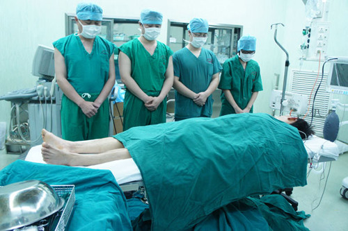 Doctors mourn a deceased donor before harvesting organs on April 23, 2011 at the operating room of the General Hospital of Guangzhou Military Command of PLA in Guangzhou, the capital of Guangdong province. There are now 163 authorized organ procurement or