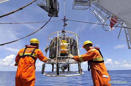 Crew members aboard the Haiyang-6 research vessel retrieve a research equipment set from the Pacific Ocean, June 11, 2012. (Xinhua/Zhou Wenjie) 