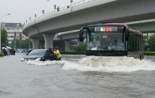 Bus and cars wade through a flooded street in Tianjin, north China, July 26, 2012. Heavy rainfall hit the municipality from Wednesday afternoon to Thursday. (Xinhua/Yue Yuewei)