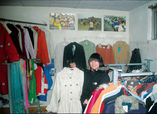 Chen Zhiyan, a 22-year-old shop owner, shows an article of clothing in the Tongxinhuhui charity store in Dongyao village, in Chaoyang district of Beijing.