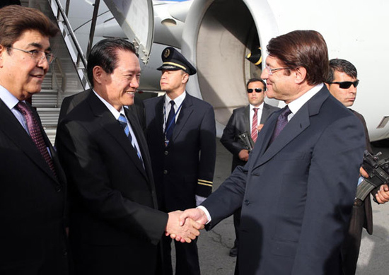 ZhouYongkang, second left, a member of the Standing Committee of the Political Bureau of the Communist Party of China Central Committee, is welcomed by Afghan Commerce and Industry Minister Anwar Ul-haq Ahady upon his arrival in Kabul for an official good