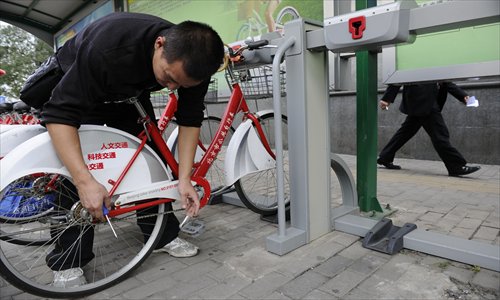 A repairman checks a bike at a rental station in Chaoyang district Thursday. Photo: Li Hao/GT 