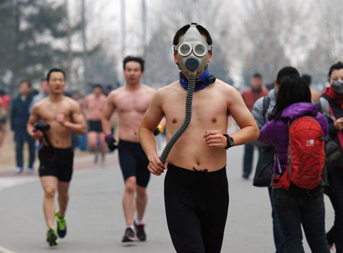 A man wears a gas mask as he takes part in a running event promoting an environmentally friendly lifestyle at the Olympic Forest Park in Beijing on Sunday. WEI XIAOHAO / CHINA DAILY