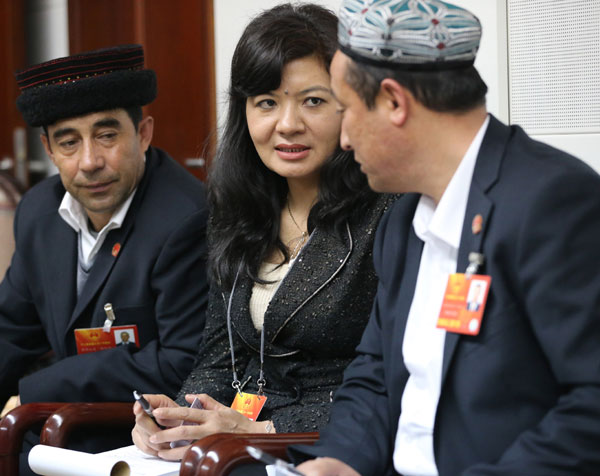Nurgul Kerim (center) interprets during a panel discussion of the delegation of the Xinjiang Uygur autonomous region on Wednesday. JIANG DONG / CHINA DAILY