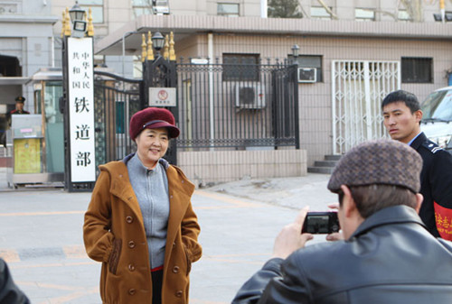 Staff members take photographs at the entrance of the Ministry of Railways, which will be dissolved. Zhu Xingxin / China Daily