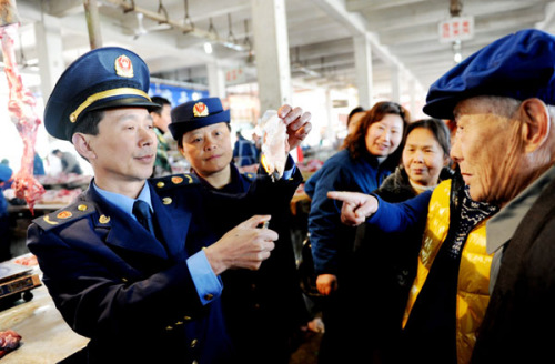 Officials from the industry and commerce administration in Dexing, Jiangxi province, introduce methods to tell if water has been injected into meat, during an activity on Wednesday to mark World Consumer Rights Day, which falls on Friday. ZHUO ZHONGWEI / 