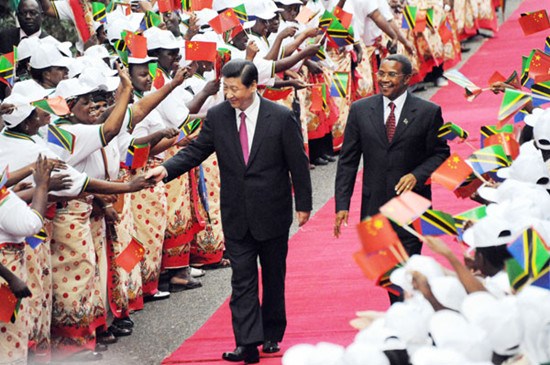President Xi Jinping, accompanied by Tanzanian President Jakaya Mrisho Kikwete, greets a welcoming crowd on his arrival at Julius Nyerere International Airport in Dar es Salaam on Sunday. Khalfan Said /AP