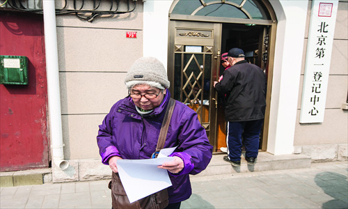 An elderly lady looks at documents after going to a new free will writing service in Hepingmen, Xicheng district. Photo: Li Hao/GT