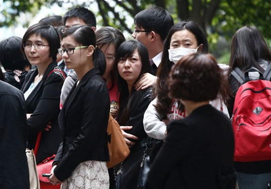 Classmates of Huang Yang, a medical student who died after drinking water laced with a toxic chemical, mourn his death at Zhongshan Hospital in Shanghai on Wednesday. ZHANG RUILIN / FOR CHINA DAILY