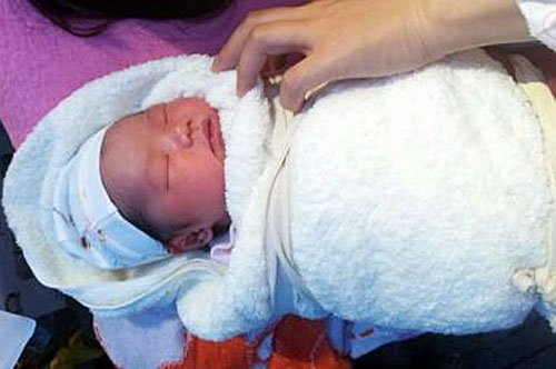 A baby was born at a makeshift tent at the People's Hospital of Ya'an, Sichuan province after a 7.0-magnitude earthquake hit the area on Saturday morning. [Photo/Xinhua]