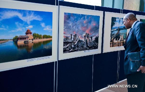 A visitor looks at pictures on display during an exhibition promoting tourism of Chinese capital city Beijing, at the United Nations headquarters in New York, on May 8, 2013. (Xinhua/Niu Xiaolei)  