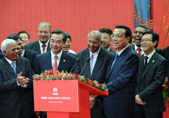 Premier Li Keqiang laughs during a video conference with Chinese employees of India's tea-to-software conglomerate Tata Group at the Tata Consultancy Services software facility in Mumbai on Tuesday. INDRANIL MUKHERJEE / AFP