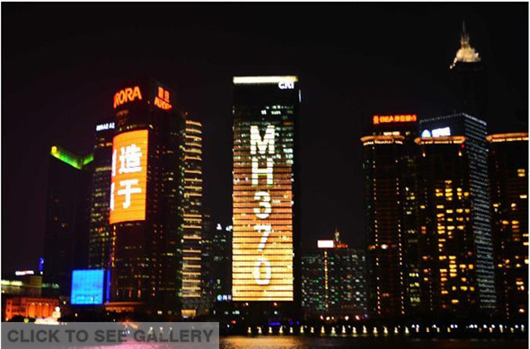 Photo taken on March 11, 2014 shows "MH370, We Are Waiting for You Back Home" displayed on a skyscraper at the Lujiazui Financial District in Shanghai, east China. (Xinhua/Shen Chunchen)