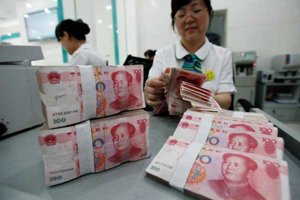 A teller counts bank notes at one of Industrial and Commercial Bank of China Ltd's branches in Huaibei, Anhui province. (Photo/ China Daily)