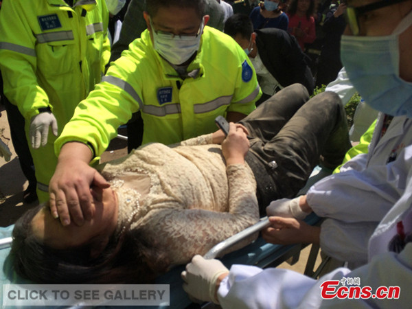 A resident is rescued from debris after a five-story residential building in the city of Fenghua in east China's Zhejiang province collapses on April 4, 2014.
