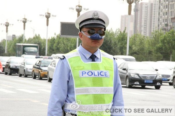 A traffic police, wearing an anti-smog nasal air filter, is on duty in Shijiazhuang of Hebei province. [Photo/ Weibo account of Hebei Daily]