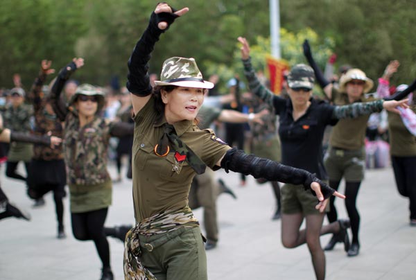 Dancers at a park in Beijing wear clothes inspired by military uniforms. Square dancers attract crowds of spectators by wearing colorful costumes and choreographing their own steps. (Photo: Zou Hong/China Daily) Dancers at a park in Beijing wear clothes inspired by military uniforms. Square dancers attract crowds of spectators by wearing colorful costumes and choreographing their own steps. (Photo: Zou Hong/China Daily)