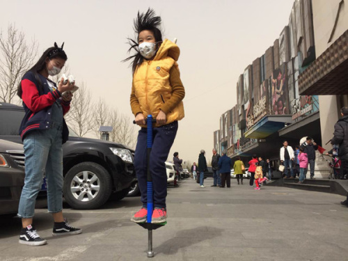 Residents wearing masks participate in outdoor activities on Lincui Road in Beijing on Saturday. The Beijing Meteorological Bureau issued a blue warning for a coming storm that was expected to increase dust levels. (Photo: Wang Jing/China Daily) Residents wearing masks participate in outdoor activities on Lincui Road in Beijing on Saturday. The Beijing Meteorological Bureau issued a blue warning for a coming storm that was expected to increase dust levels. (Photo: Wang Jing/China Daily)