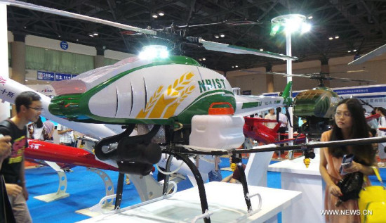 Visitors view an unmanned aerial vehicle (UAV) displayed at a UAV Show in Beijing, capital of China, July 10, 2014. (Xinhua/Li Mingfang)