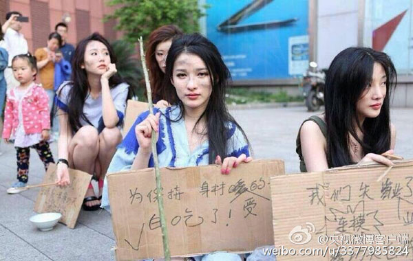 Showgirls dressed as beggars carry placards during the protest. (Photo from Sina Weibo) Showgirls dressed as beggars carry placards during the protest. (Photo from Sina Weibo)