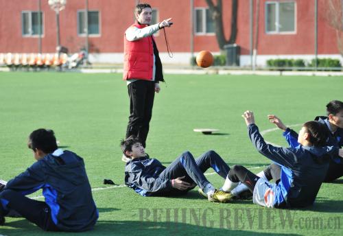 FOREIGN EXPERTISE: Marko Tomic, a 31-year-old assistant coach from Serbia, guides students in their warm up before regular training starts on a field inside the Sangao training base on April 7 (WEI YAO) FOREIGN EXPERTISE: Marko Tomic, a 31-year-old assistant coach from Serbia, guides students in their warm up before regular training starts on a field inside the Sangao training base on April 7 (WEI YAO)