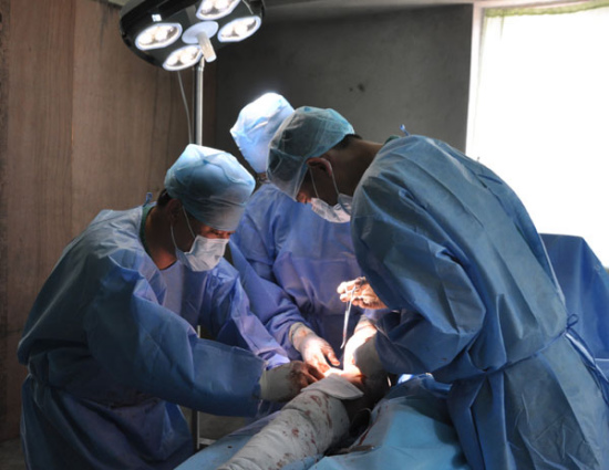 Doctors from the Chengdu military medical team do an operation on a 16-year-old Nepali girl, who broke her right leg, at a field hospital in Kathmandu on Friday.[Photo by Zhao Yanrong/China Daily]