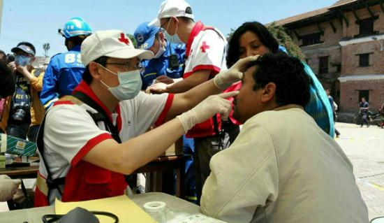A Chinese doctor treats a Nepali patient on Sunday who was affected by the magnitude-7.9 earthquake in Kathmandu. (Cheng Ying/Xinhua)