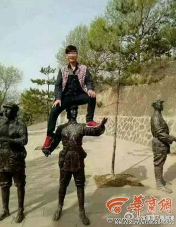Tourist Li Wenchun climbs on top of a Red Army statue for a photo on April 23, 2015. Photo/Weibo