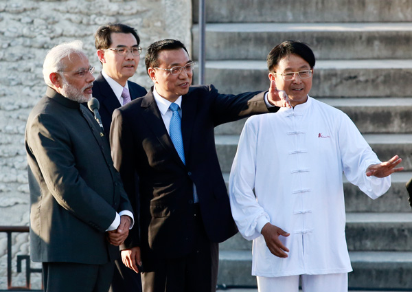 Premier Li Keqiang and visiting Indian Prime Minister Narendra Modi watch a yoga and tai chi exercise event at Temple of Heaven Park in Beijing on Friday.[Photo by FENG YONGBIN / CHINA DAILY]