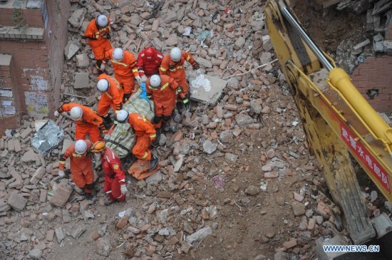 Rescuers carry a victim's body in Guiyang, capital of southwest China's Guizhou Province, May 21, 2015. Five bodies were found in the rubble of a collapsed building in central Guiyang Thursday. The accident happened on Wednesday, when the nine-story building with 114 residents living in it fell down. (Xinhua/Ou Dongqu) Rescuers carry a victim's body in Guiyang, capital of southwest China's Guizhou Province, May 21, 2015. Five bodies were found in the rubble of a collapsed building in central Guiyang Thursday. The accident happened on Wednesday, when the nine-story building with 114 residents living in it fell down. (Xinhua/Ou Dongqu)