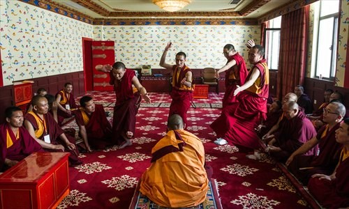 During a graduate exam for Nyingma sect lamas, a Tho Ram Pa program student (sitting in the center) of the High-level Tibetan Buddhism College of China is challenged by four Buddhist scripture debaters invited by the college from other temples to test the candidate. (Photo: GT/Li Hao) During a graduate exam for Nyingma sect lamas, a Tho Ram Pa program student (sitting in the center) of the High-level Tibetan Buddhism College of China is challenged by four Buddhist scripture debaters invited by the college from other temples to test the candidate. (Photo: GT/Li Hao)
