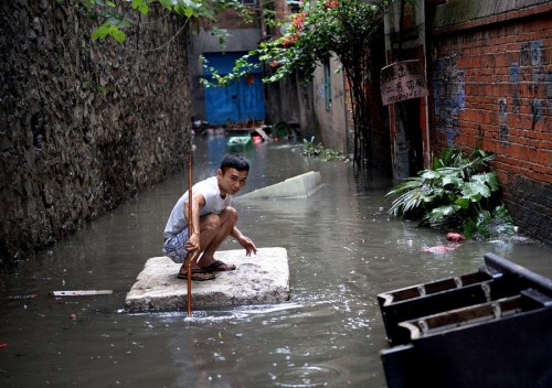 A man balances on a foam raft after heavy rain hit the southwestern province of Guangxi on Wednesday. More downpours are expected in South China during the coming days. (Photo/Asianewsphoto) A man balances on a foam raft after heavy rain hit the southwestern province of Guangxi on Wednesday. More downpours are expected in South China during the coming days. (Photo/Asianewsphoto)