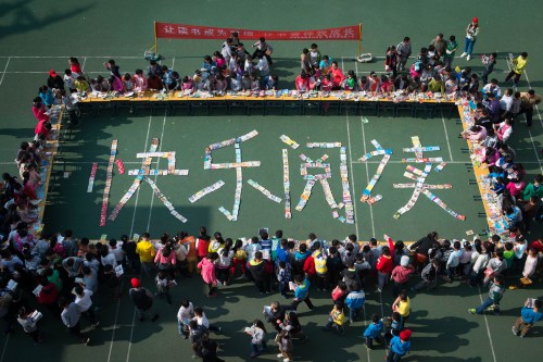 Pupils in Shenglilu Primary School exchange books on March 31 (XINHUA) 