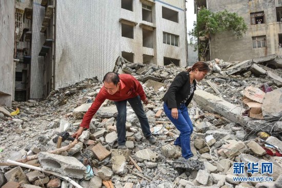Ji Yuankui (L) and Luo Kaisu (R) looks for items among debris on June 11.(Photo: Xinhua/Liu Xu) Ji Yuankui (L) and Luo Kaisu (R) looks for items among debris on June 11.(Photo: Xinhua/Liu Xu)
