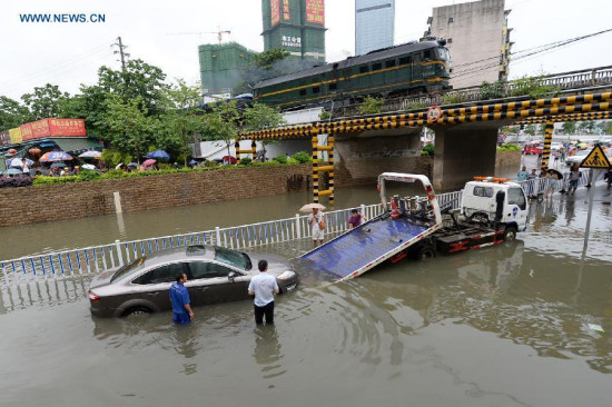 People transfer a flooded car in Liuzhou City, south China's Guangxi Zhuang Autonomous Region, June 14, 2015. The National Meteorological Center (NMC) issued a yellow alert for rainstorms in southern China on Sunday. (Photo: Xinhua/Li Hanchi) People transfer a flooded car in Liuzhou City, south China's Guangxi Zhuang Autonomous Region, June 14, 2015. The National Meteorological Center (NMC) issued a yellow alert for rainstorms in southern China on Sunday. (Photo: Xinhua/Li Hanchi)