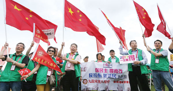 Residents of Kowloon East wave national flags and shout slogans in support for the electoral reform package at a rally in Tamar Park on June 6, 2015. (Parker Zheng / China Daily) Residents of Kowloon East wave national flags and shout slogans in support for the electoral reform package at a rally in Tamar Park on June 6, 2015. (Parker Zheng / China Daily)