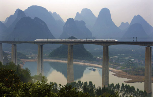 A high-speed train crosses a bridge in Yangshuo in the Guangxi Zhuang autonomous region. China's longest high-speed railway service, which links Beijing and Nanning, capital of the Guangxi, is 2,489 kilometers in length. (Photo/China Daily) A high-speed train crosses a bridge in Yangshuo in the Guangxi Zhuang autonomous region. China's longest high-speed railway service, which links Beijing and Nanning, capital of the Guangxi, is 2,489 kilometers in length. (Photo/China Daily)