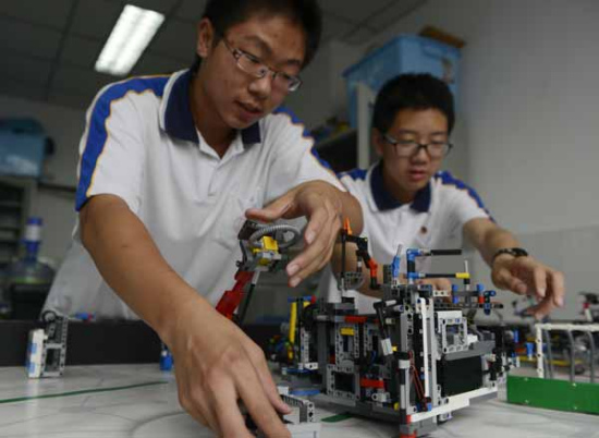 Guo Zhuoxuan (left) and Zhang Xinyu, members of a robotics club at the middle and high school affiliated with Jiaotong University in Beijing, calibrate their robot on Thursday. (Wei Xiaohao/China Daily) Guo Zhuoxuan (left) and Zhang Xinyu, members of a robotics club at the middle and high school affiliated with Jiaotong University in Beijing, calibrate their robot on Thursday. (Wei Xiaohao/China Daily)