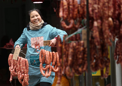 A woman in Xi'an, Shaanxi province, puts newly made sausages outside to dry them. (Photo/China Daily) A woman in Xi'an, Shaanxi province, puts newly made sausages outside to dry them. (Photo/China Daily)