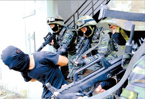 Armed police officers arrest a “terrorist” yesterday during an exercise in the Pudong New Area. About 200 personnel, two assault boats, four armed vehicles and a helicopter from an anti-terrorist unit took part in the drill, which was staged to test the city’s capabilities in dealing with such a threat. (Photo/Xinhu)a Armed police officers arrest a “terrorist” yesterday during an exercise in the Pudong New Area. About 200 personnel, two assault boats, four armed vehicles and a helicopter from an anti-terrorist unit took part in the drill, which was staged to test the city’s capabilities in dealing with such a threat. (Photo/Xinhu)a