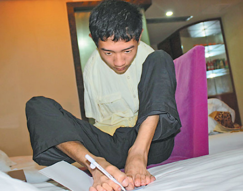 Peng Chao writes with one foot on his bed in a hotel room in Chengdu, Sichuan province, in early July. (Huang Leran/for China Daily) Peng Chao writes with one foot on his bed in a hotel room in Chengdu, Sichuan province, in early July. (Huang Leran/for China Daily)