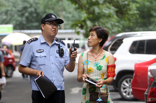 Yu Xiaohui, a resident of Beijing's Nongzhan Nanli community in Chaoyang district, tours the area with Wang Yang, a police officer. Yu is a volunteer who helps police keep a watch on the neighborhood. (Zou Hong/China Daily) Yu Xiaohui, a resident of Beijing's Nongzhan Nanli community in Chaoyang district, tours the area with Wang Yang, a police officer. Yu is a volunteer who helps police keep a watch on the neighborhood. (Zou Hong/China Daily)