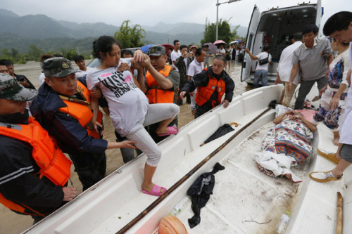 Rescuers help a pregnant woman board a boat taking her to a hospital in Ruian, Zhejiang province. Heavy rain hit the city on Sunday. (Sun Lin/China Daily) Rescuers help a pregnant woman board a boat taking her to a hospital in Ruian, Zhejiang province. Heavy rain hit the city on Sunday. (Sun Lin/China Daily)