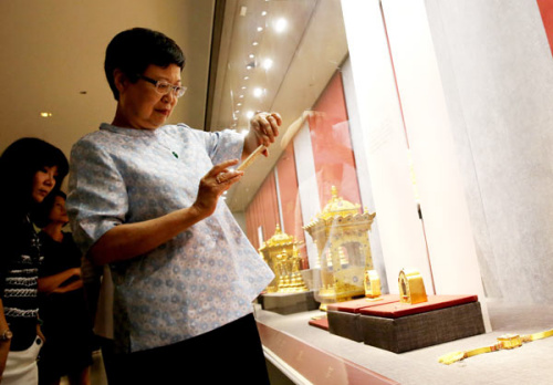 Fung Ming-Chu, director of Taipei's National Palace Museum, takes photos of the displayed relics at the Olympic Park Observation Tower in Beijing on Tuesday. (China Daily/Jiang Dong)
