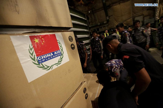Myanmar policemen carry relief aid from a cargo plane at the Yangon International Airport in Yangon, Myanmar, Aug. 15, 2015. The emergency relief aid from the Chinese government arrived at the Yangon International Airport on Saturday night to help flood victims in Myanmar. (Xinhua/U Aung) Myanmar policemen carry relief aid from a cargo plane at the Yangon International Airport in Yangon, Myanmar, Aug. 15, 2015. The emergency relief aid from the Chinese government arrived at the Yangon International Airport on Saturday night to help flood victims in Myanmar. (Xinhua/U Aung)