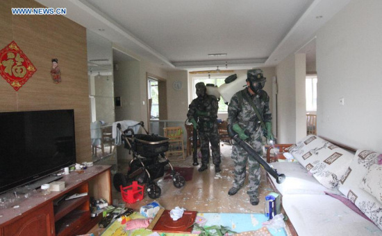 Military specialists in handling nuclear and biochemical materials decontaminate at a residential community near the core area of the warehouse explosion site in Tianjin, north China, Aug. 18, 2015. (Photo: Xinhua/Wang Haobo)