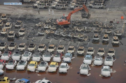 Rescuers clear the damaged imported cars near the core blast area in Tianjin, north China, Aug. 20, 2015. (Photo: Xinhua/Yin Dongxun)
