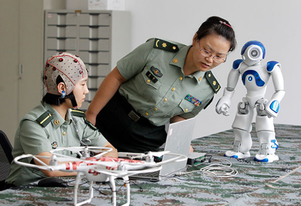 Two researchers at the PLA Information Engineering University test how to control robots with the mind.(Photo/China Daily) Two researchers at the PLA Information Engineering University test how to control robots with the mind.(Photo/China Daily)